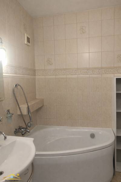 Badezimmer einer 3-Zimmer-Wohnung mit Badewanne und beigefarbenen Wandfliesen.