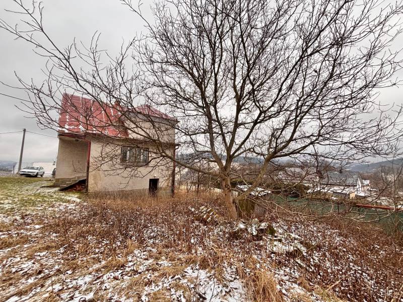 Ein Einfamilienhaus auf der Poľana in Skalité ohne Laubbewuchs, mit einer Umgebung, die von feinem Schnee bedeckt ist.