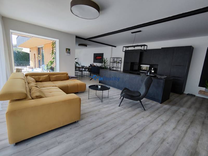 Wohnzimmer in einem Einfamilienhaus mit Holzboden und bequemer Couch.