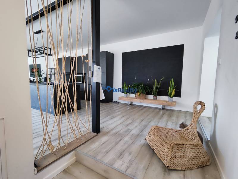 Innenraum eines Einfamilienhauses mit Holzboden, Pflanzen und Seildekoration.