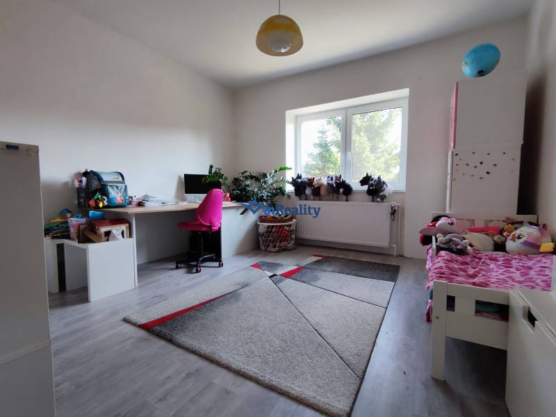 Kinderzimmer in einem Einfamilienhaus mit Holzboden, Schreibtisch und Spielzeug.