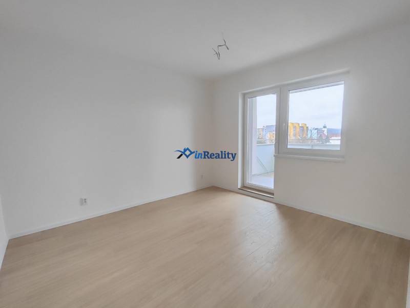 Ein leeres Zimmer in einer 2-Zimmer-Wohnung mit Holzboden und Balkontür.