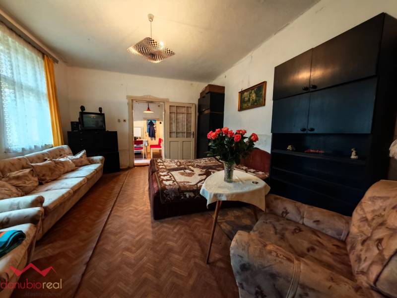 Wohnzimmer in einem Einfamilienhaus mit Sofas, Fernseher und Boden in Holzoptik.