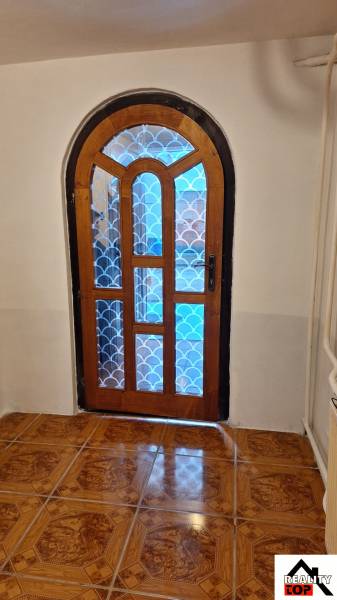 Gewölbte Holztüren mit gemustertem Glas im Einfamilienhaus, Boden mit Holzdekor.