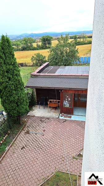 Der Garten eines Einfamilienhauses in Zacharovce mit einem Pavillon, Bäumen und Blick auf das Feld.