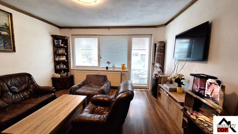 Wohnzimmer in einem Einfamilienhaus mit Ledermöbeln und Holzboden.