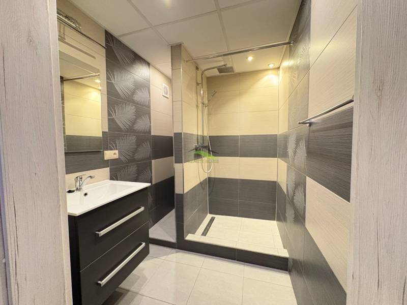 Badezimmer mit Dusche und Waschbecken in einer 3-Zimmer-Wohnung.