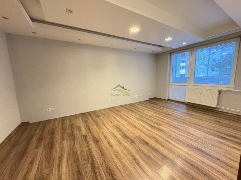 Wohnzimmer in einer 3-Zimmer-Wohnung mit Holzboden und großem Fenster.