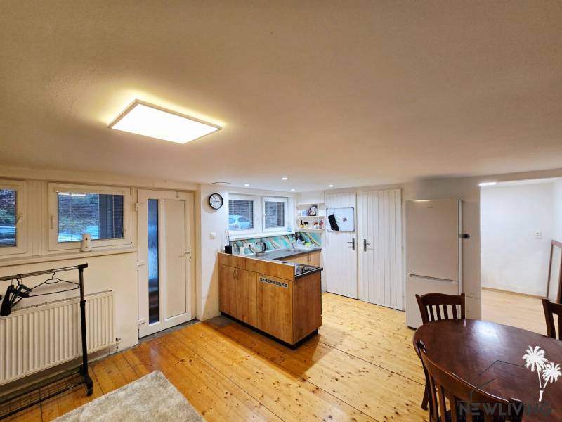 Küche in einer Einzimmerwohnung mit Holzboden und Tisch.