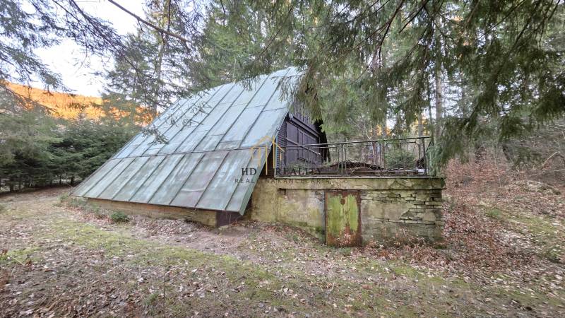 Hütte im Wald Krpáčovo in der Straße Krpáčovo mit Blechdach und Steinsockel.