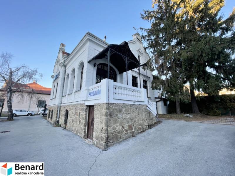 Das Gebäude in der Vajanského-Straße in Prešov mit einem eleganten Steinsockel und einer weißen Fassade.