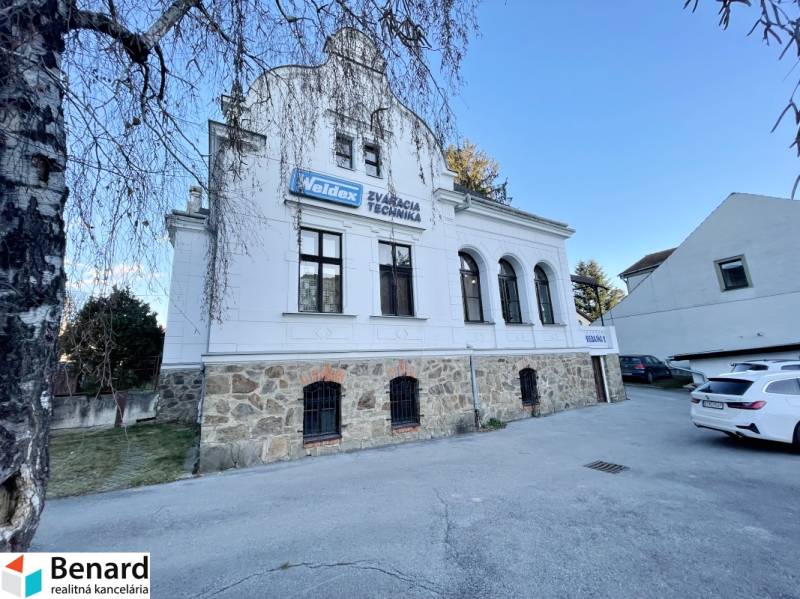 Das Gebäude in der Vajanského-Straße in Prešov mit einem steinernen Erdgeschoss und einer weißen Fassade.