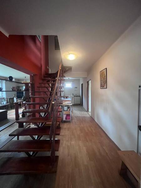 Innenraum eines Einfamilienhauses mit Holztreppe und Boden in Holzoptik.