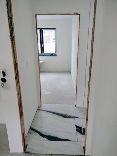 Rekonstruktion des Innenraums eines Einfamilienhauses mit weißen Wänden und Marmorboden.