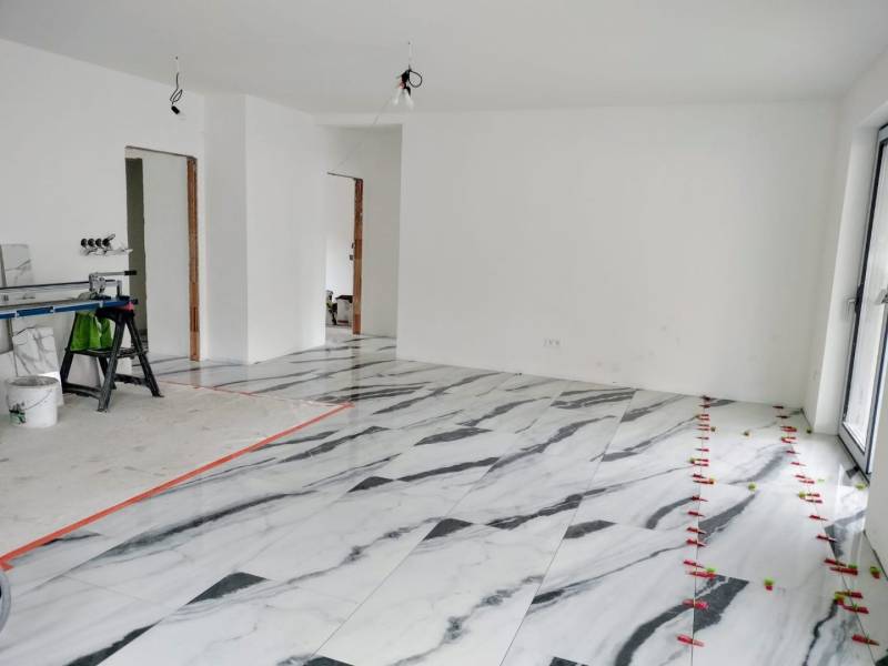 Innenraum eines Einfamilienhauses mit Marmorboden und weißen Wänden.