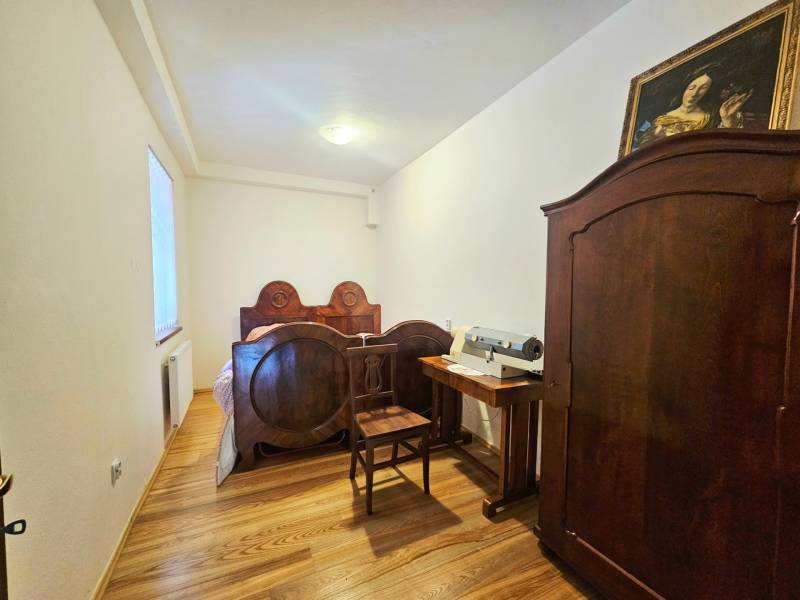 Schlafzimmer mit antiken Möbeln, Bett und Schrank mit Holzboden.