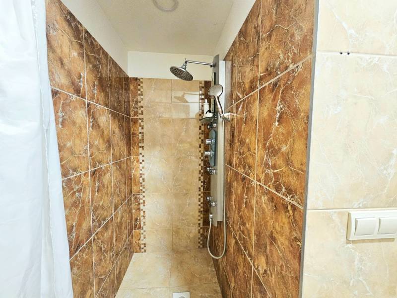 Duschkabine mit Keramikfliesen und Vorhang in einer 3-Zimmer-Wohnung.