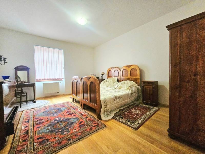 Schlafzimmer in einer 3-Zimmer-Wohnung mit Holzelementen und Vintage-Möbeln.