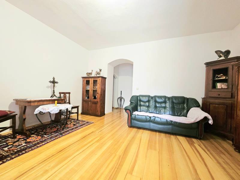 Wohnzimmer in einer 3-Zimmer-Wohnung mit Holzboden und Holzmöbeln.