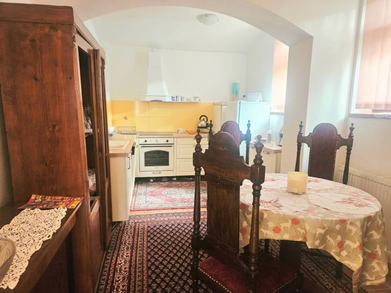 Küche in einer 3-Zimmer-Wohnung mit Holzmöbeln und Vintage-Teppich.