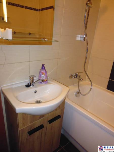 Badezimmer mit Badewanne und Waschbecken in einer 2-Zimmer-Wohnung.