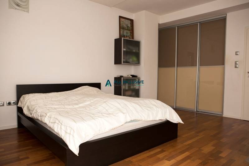 Schlafzimmer in einem Einfamilienhaus mit Bett und Schrank, Boden mit Holzdekor.