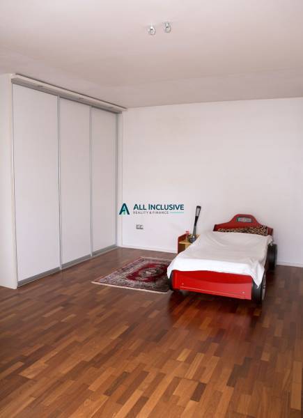 Kinderzimmer in einem Einfamilienhaus mit einem Bett in Form eines Autos und einem Boden mit Holzdekor.