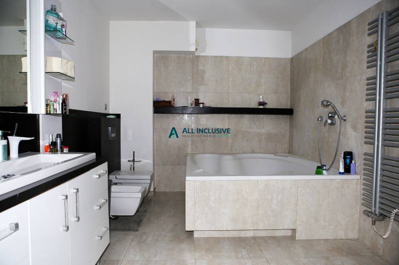 Ein Badezimmer mit einer großen Badewanne und hellen Fliesen in einem Einfamilienhaus.