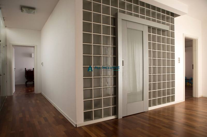 Innenraum eines Einfamilienhauses mit Glastüren und einem Boden in Holzoptik.