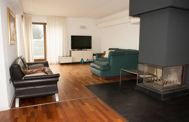 Wohnzimmer mit Kamin, Fernseher und Holzboden in einem Einfamilienhaus.