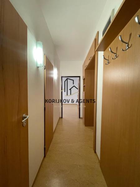 Der Flur in der 2-Zimmer-Wohnung mit einem Boden in Holzoptik und einer Garderobe an der Wand.