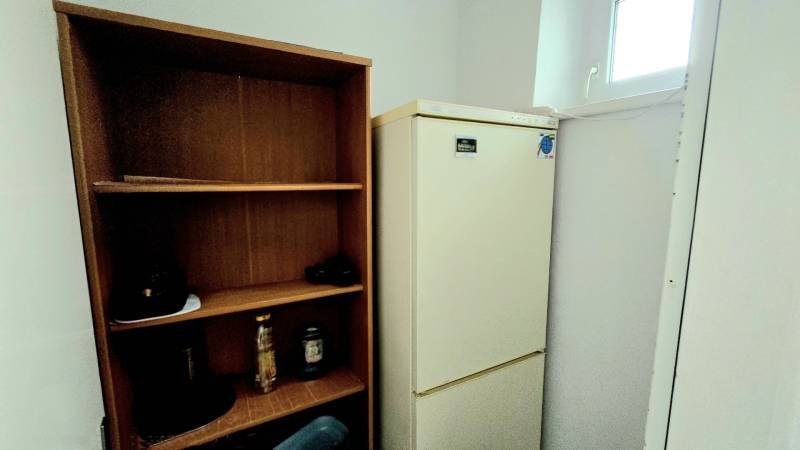 Chladnička und Holzregal in einer 3-Zimmer-Wohnung.