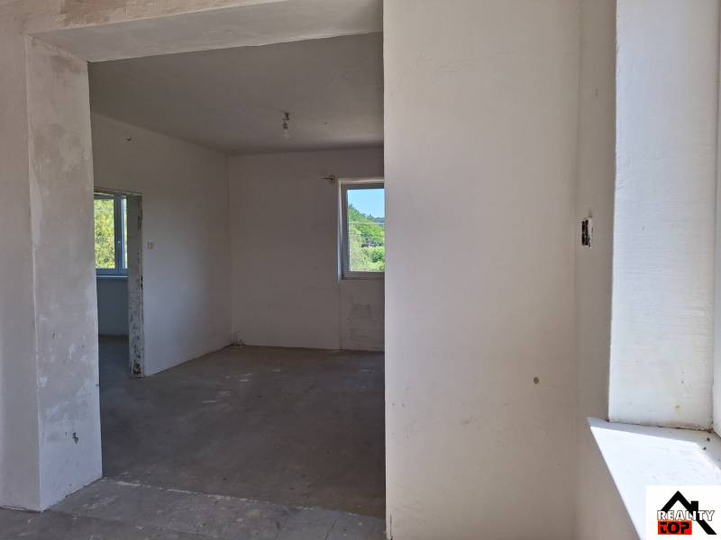 Innenraum eines Einfamilienhauses mit unfertigen Wänden und Betonboden.