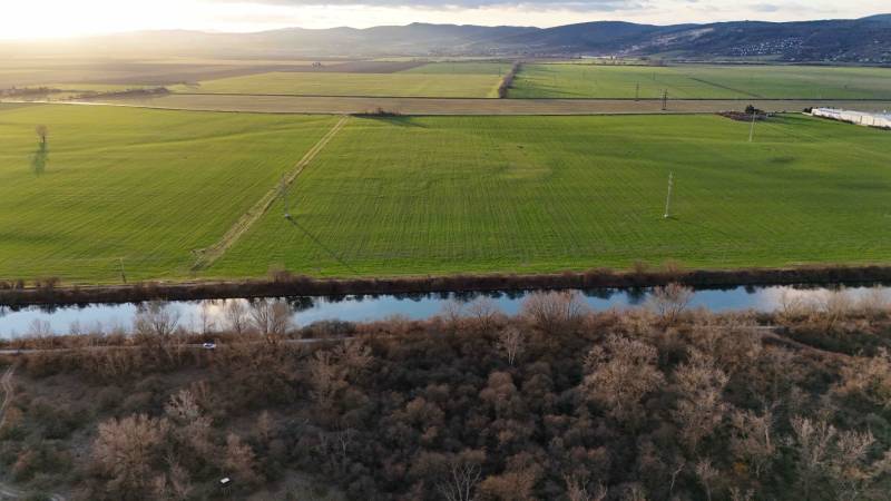 Blick auf grüne Felder, den Fluss und Wälder in der Umgebung von Nová Ves nad Váhom.
