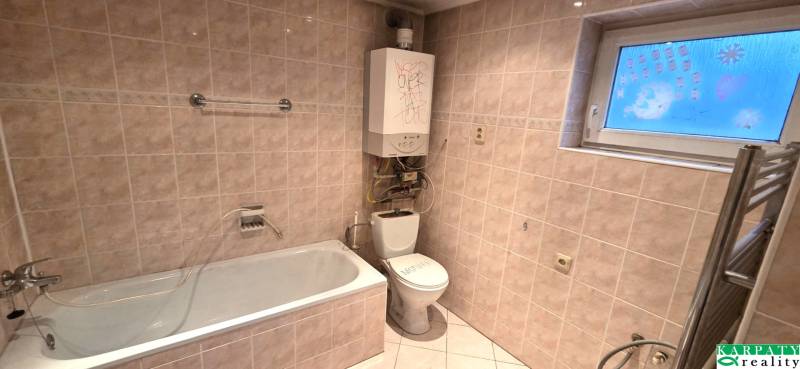 Badezimmer in einem Einfamilienhaus mit Badewanne, Toilette und Wandheizung.