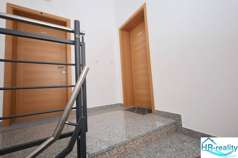 Eine Treppe mit einem Metallgeländer und Holztüren in einem Ferienapartment.