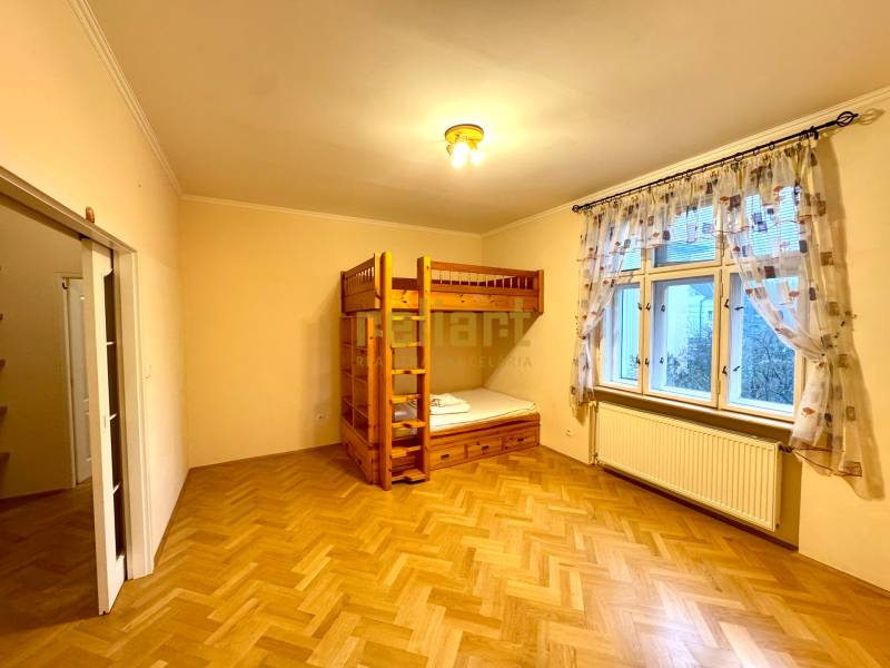 Schlafzimmer in einer 4-Zimmer-Wohnung mit einem Etagenbett und einem Boden mit Holzdekor.