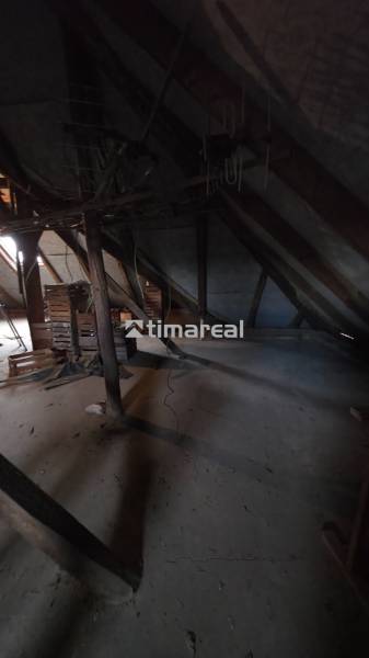 Der Dachboden eines Einfamilienhauses mit Holzbalken und gelagerten Kisten.