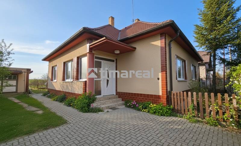 Ein Einfamilienhaus in Križovany nad Dudváhom mit einem gepflegten Garten und einem gepflasterten Gehweg.