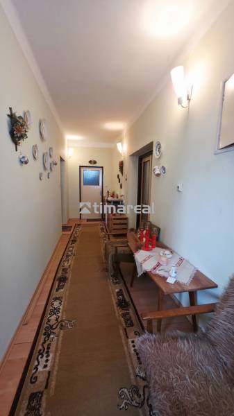 Der Flur im Einfamilienhaus mit dekorativen Tellern an der Wand und einem Teppich.