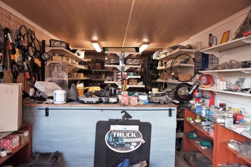 Autoteileladen mit Regalen voller Teile und Zubehör in Produktionsräumen.