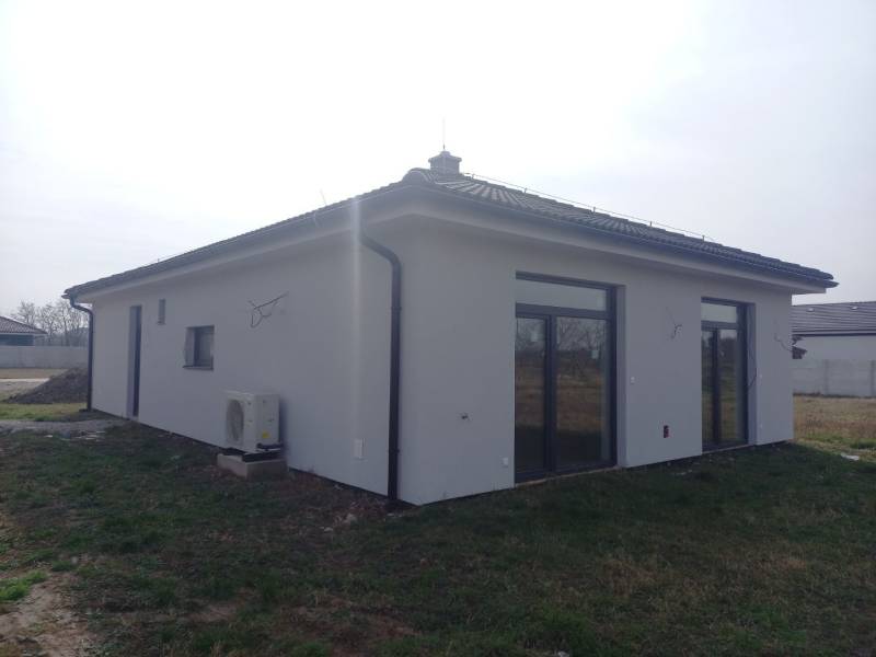 Ein Einfamilienhaus in Galanta mit weißer Fassade und Fenstern mit Glasbausteinen.