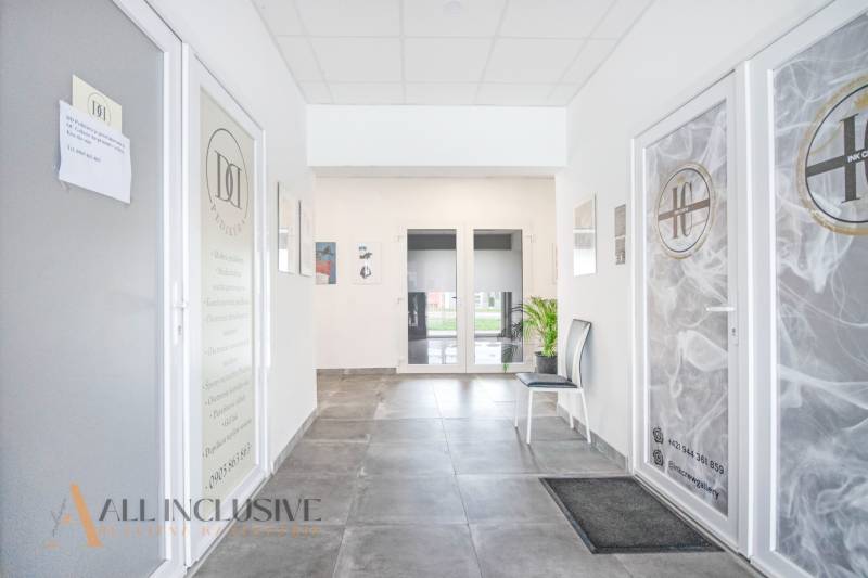 Ein heller Innenraum mit Türen zu Geschäftsräumen in der Vajanského-Straße mit der Anwesenheit von Pflanzen.