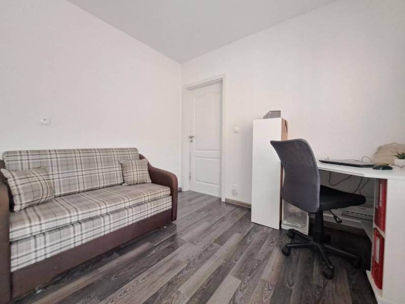 Ein Sofa und ein Schreibtisch in einem Einfamilienhaus mit Holzboden.