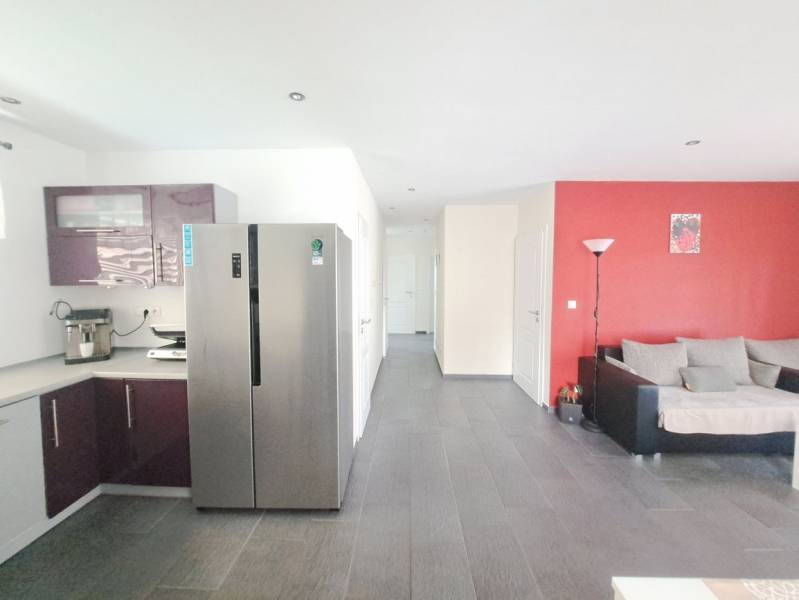 Eine Küche mit violetten Schränken und grauem Boden in einem Einfamilienhaus.