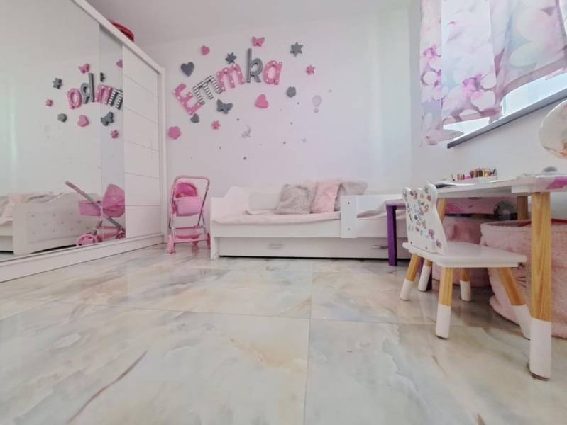 Kinderzimmer in einem Einfamilienhaus mit Dekorationen, Möbeln und Spielzeug, Boden mit Holzdekor.