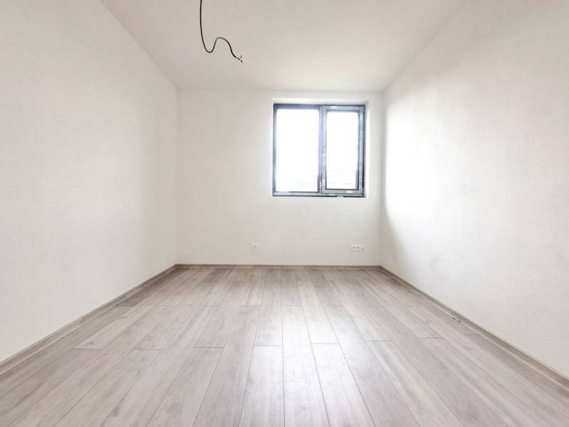 Ein leerer Raum mit Holzdekorboden und einem Fenster in einem Einfamilienhaus.