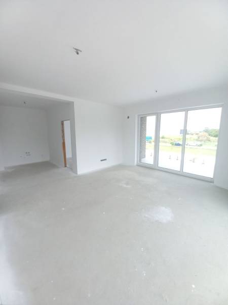 Helles Wohnzimmer in einer 2-Zimmer-Wohnung mit großen Fenstern und leerem Boden.