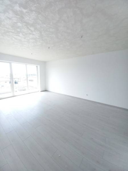 Helles Zimmer mit Holzboden in einer 2-Zimmer-Wohnung.