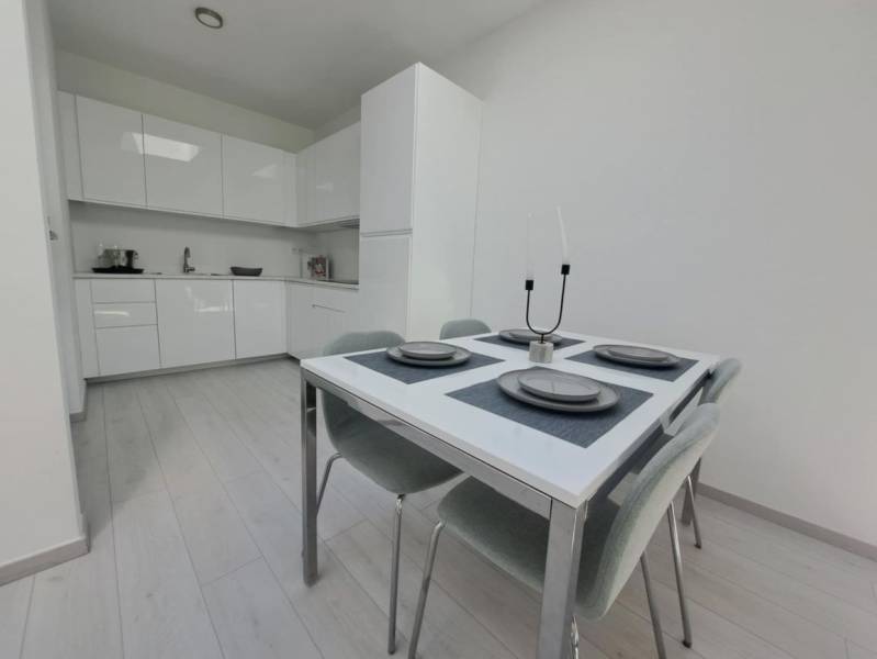 Essbereich in einer 2-Zimmer-Wohnung mit Küchenzeile und Boden in Holzoptik.